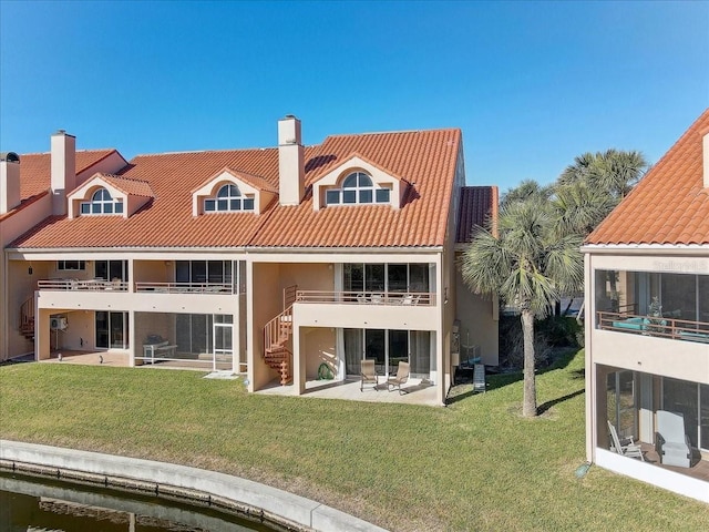 rear view of property featuring a yard and a patio