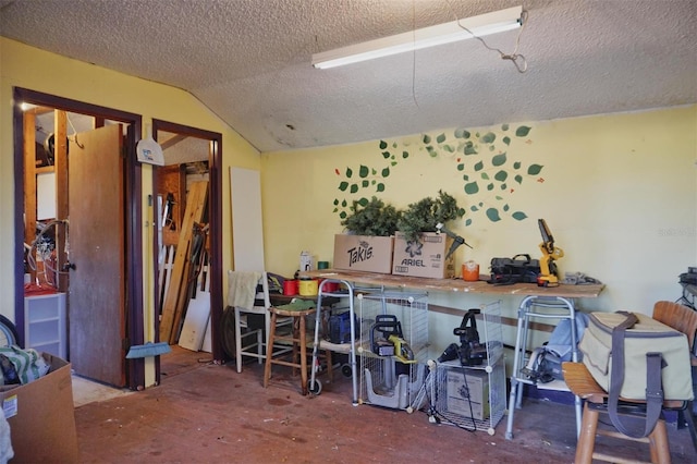 miscellaneous room featuring a textured ceiling, concrete floors, and lofted ceiling