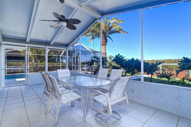 sunroom with ceiling fan and lofted ceiling with beams