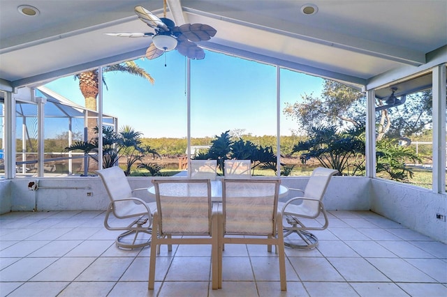 sunroom with ceiling fan and lofted ceiling with beams