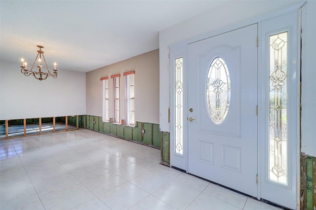 foyer featuring light tile patterned floors and a chandelier