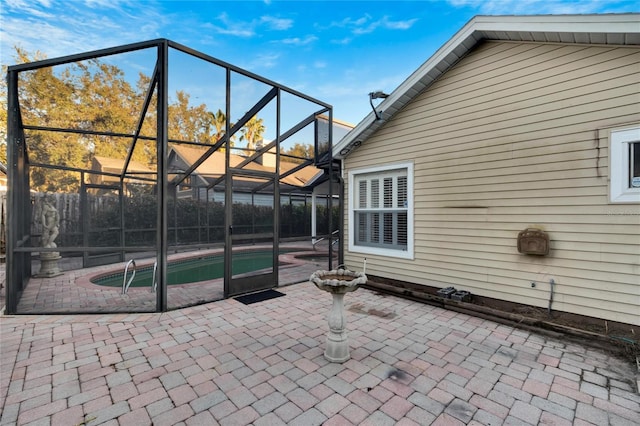 view of patio featuring glass enclosure