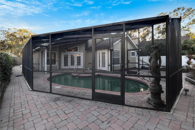 view of pool with a lanai, a patio, and french doors