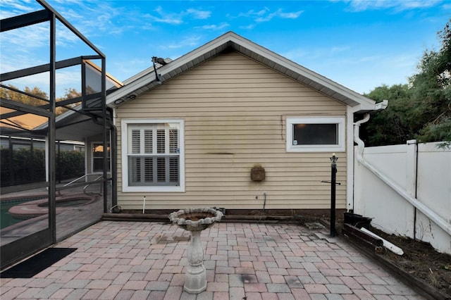 back of property featuring a patio area and a lanai