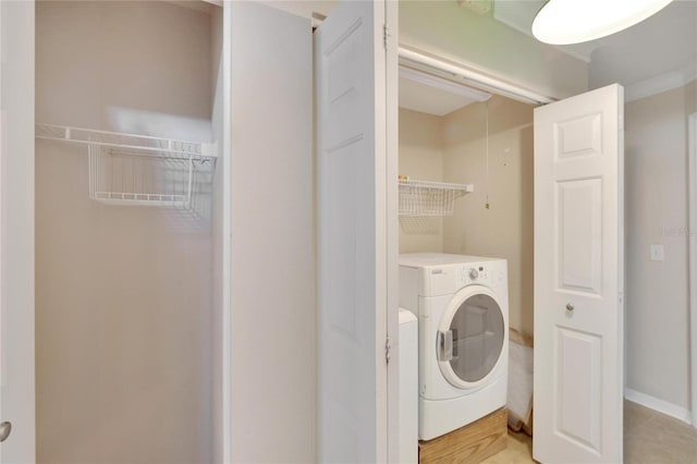 clothes washing area featuring light tile patterned floors and washer and dryer