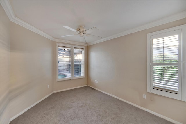 carpeted spare room with crown molding, ceiling fan, and a healthy amount of sunlight