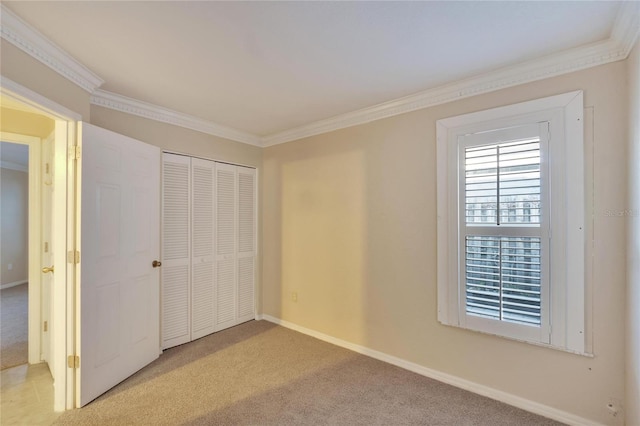 unfurnished bedroom with light colored carpet, crown molding, and a closet