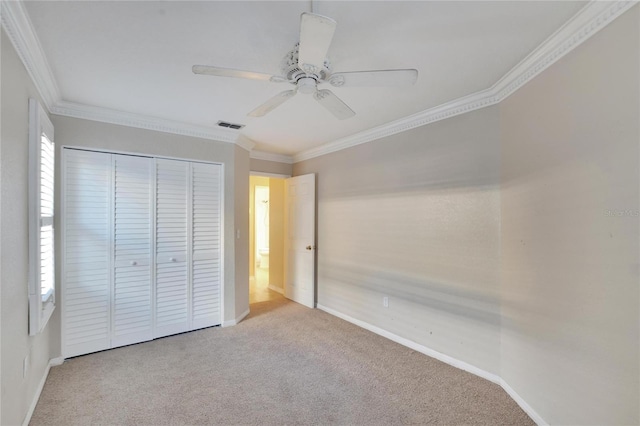 unfurnished bedroom featuring light carpet, a closet, crown molding, and ceiling fan