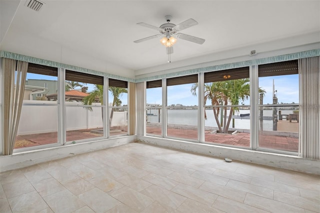 unfurnished sunroom featuring a water view and ceiling fan