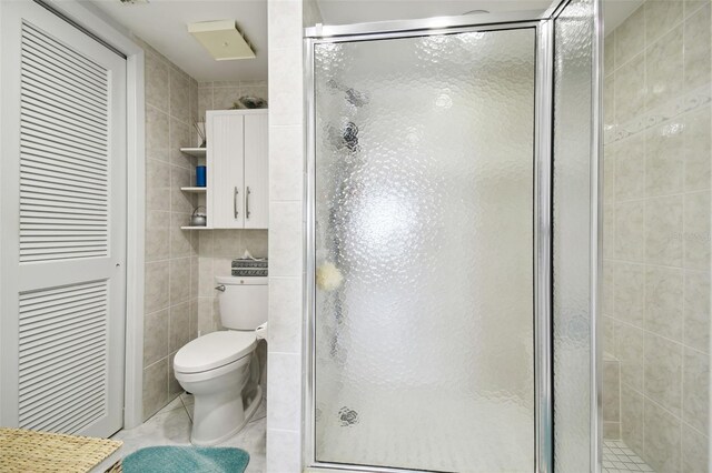 4650 Bay Blvd Unit 1046, Port Richey, FL 34668 - full bathroom with tile walls, toilet, a shower stall, and tile patterned flooring