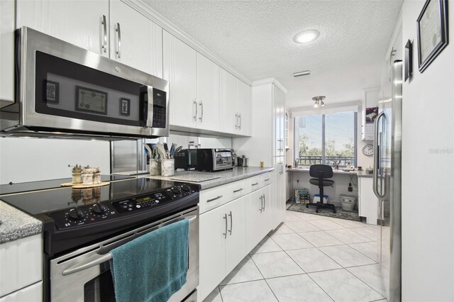 kitchen featuring light tile patterned floors, white cabinets, stainless steel appliances, and a textured ceiling