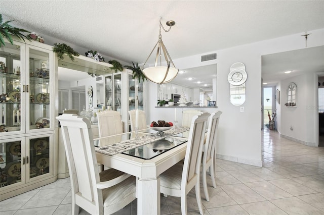 tiled dining room with a textured ceiling