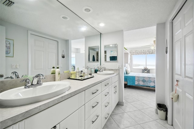 bathroom featuring tile patterned flooring, vanity, and a textured ceiling