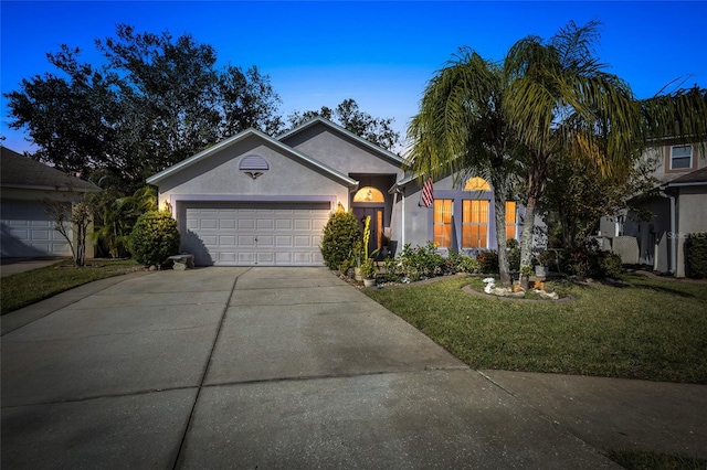 ranch-style home featuring a lawn and a garage