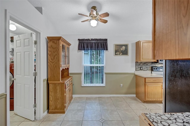 kitchen featuring ceiling fan, light tile patterned floors, a textured ceiling, and tasteful backsplash