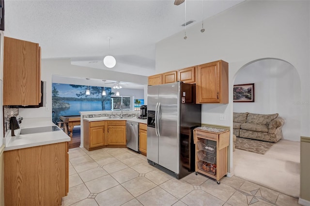 kitchen featuring sink, a textured ceiling, decorative light fixtures, kitchen peninsula, and stainless steel appliances