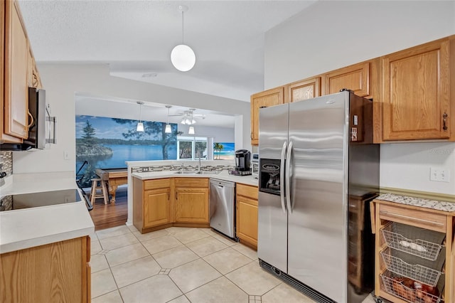 kitchen featuring ceiling fan, sink, stainless steel appliances, kitchen peninsula, and decorative light fixtures