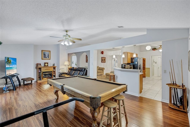 recreation room featuring ceiling fan, pool table, a textured ceiling, lofted ceiling, and light wood-type flooring