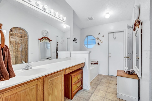 bathroom with vanity and a textured ceiling