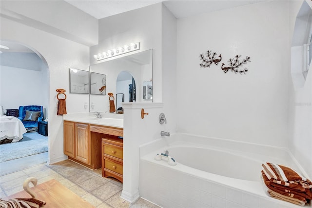 bathroom with vanity, tile patterned floors, and tiled tub