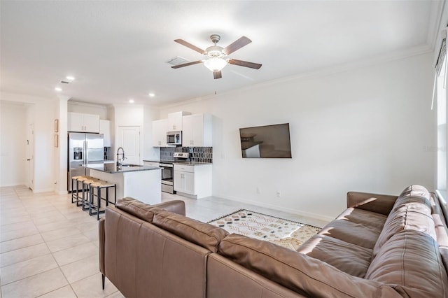 tiled living room featuring ceiling fan, sink, and ornamental molding