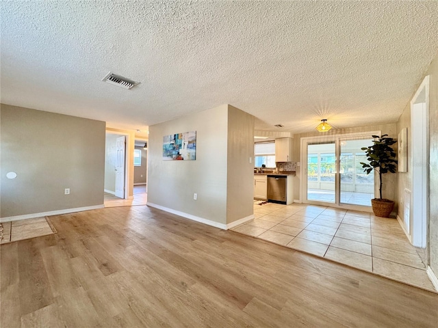 spare room with light hardwood / wood-style floors and a textured ceiling