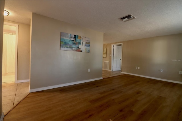 spare room with wood-type flooring and a textured ceiling