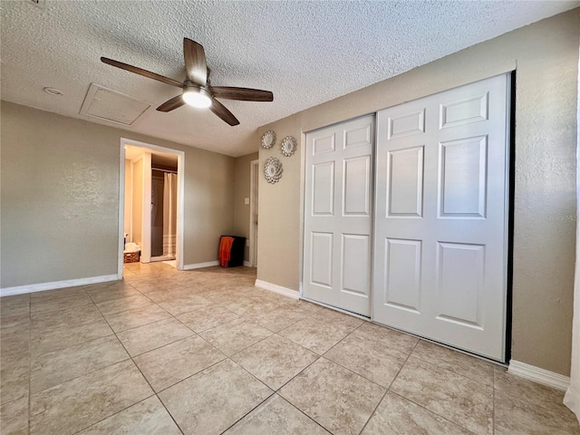 unfurnished bedroom with ceiling fan, a closet, light tile patterned floors, and a textured ceiling