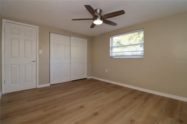 unfurnished bedroom with ceiling fan, light wood-type flooring, and a textured ceiling