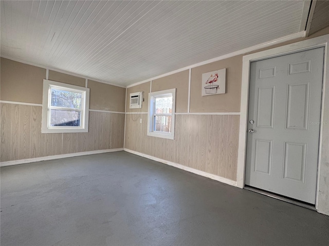 unfurnished room featuring wood walls and a wall unit AC