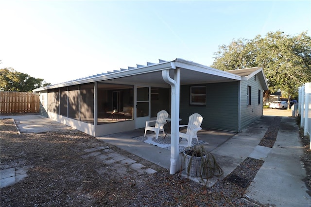 rear view of property with a patio area and a sunroom