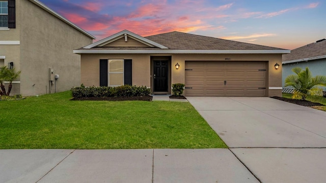 view of front of home featuring a lawn and a garage