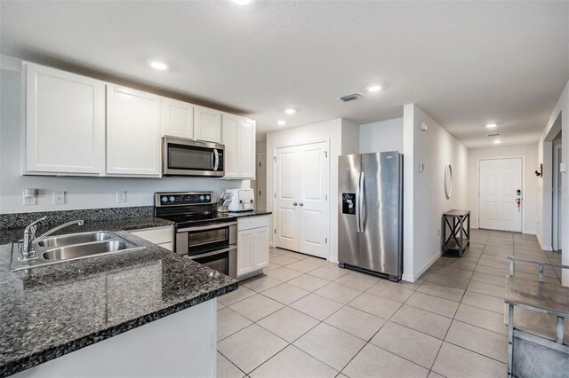 kitchen with white cabinetry, sink, light tile patterned floors, and appliances with stainless steel finishes