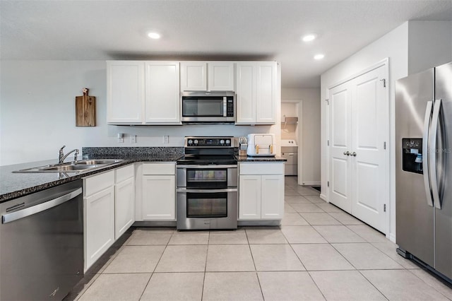 kitchen featuring light tile patterned floors, white cabinetry, sink, and appliances with stainless steel finishes