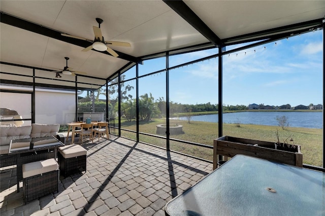 unfurnished sunroom featuring vaulted ceiling, ceiling fan, and a water view