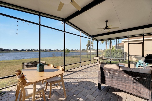 sunroom / solarium featuring a water view, lofted ceiling, and ceiling fan