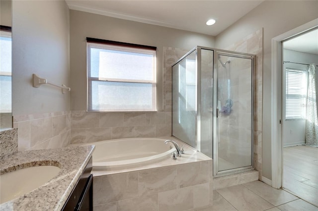 bathroom featuring tile patterned floors, vanity, separate shower and tub, and a wealth of natural light