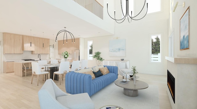 living room with a wealth of natural light, light wood-type flooring, and a notable chandelier