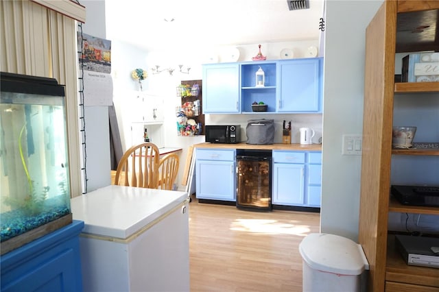 kitchen featuring white cabinets, light hardwood / wood-style flooring, and beverage cooler