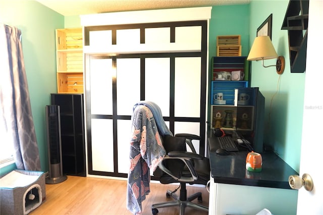 home office with light hardwood / wood-style floors