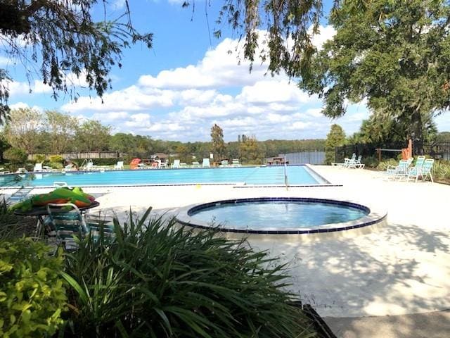 view of swimming pool with a hot tub