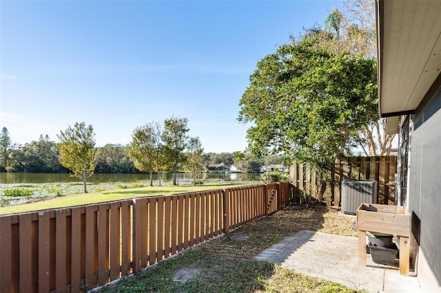 view of yard with central AC and a water view