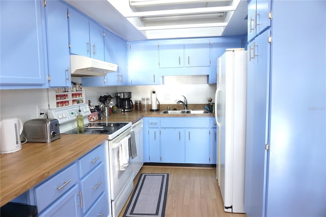 kitchen with wood counters, light wood-type flooring, white appliances, sink, and white cabinetry