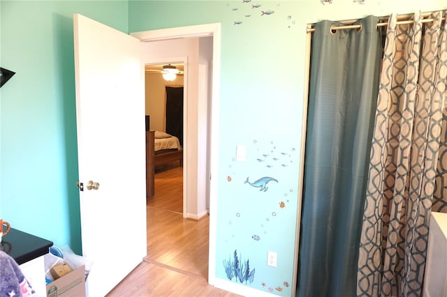 bathroom with hardwood / wood-style floors and ceiling fan