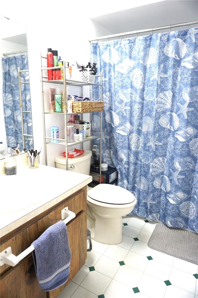 bathroom with tile patterned flooring, vanity, and toilet