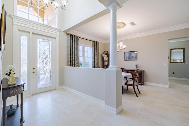 foyer with crown molding, ornate columns, and a notable chandelier