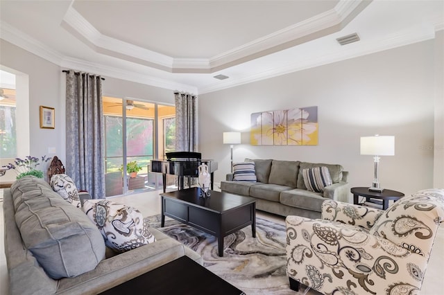 living room with ceiling fan, crown molding, and a tray ceiling