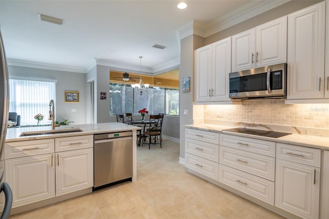 kitchen featuring pendant lighting, appliances with stainless steel finishes, white cabinetry, sink, and backsplash