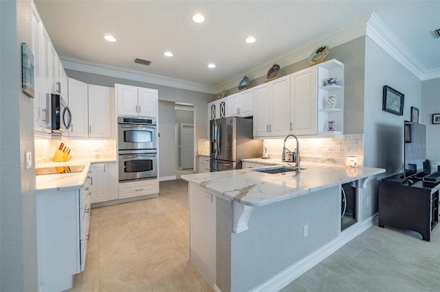 kitchen with appliances with stainless steel finishes, white cabinetry, sink, kitchen peninsula, and a breakfast bar