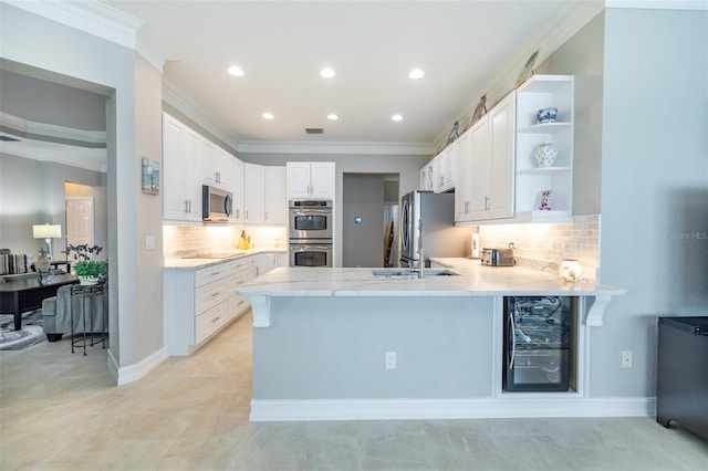 kitchen featuring beverage cooler, white cabinetry, stainless steel appliances, backsplash, and kitchen peninsula